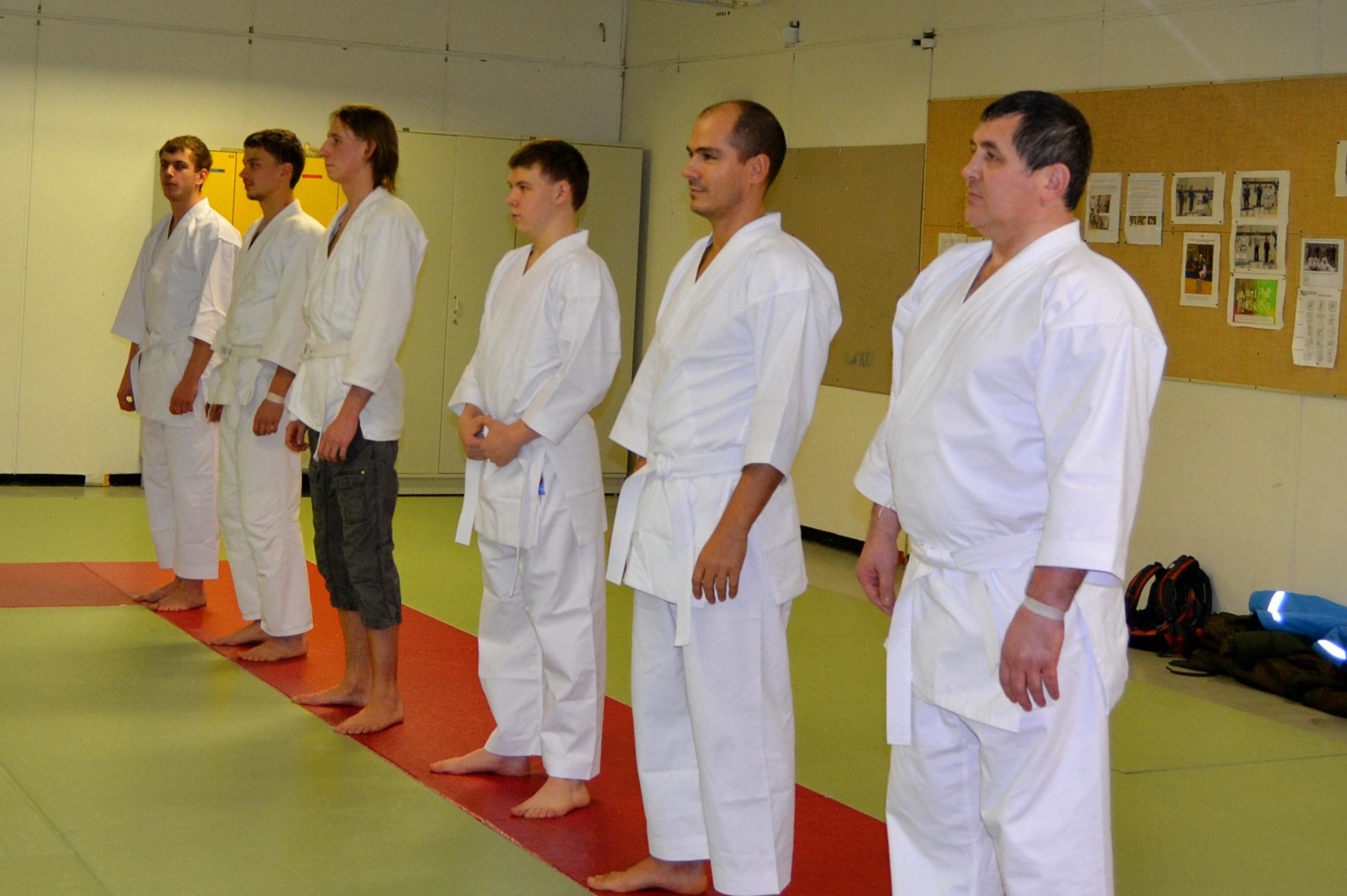 AikiJujutsun oppilaat istuvat seiza-asennossa tatamilla keltaiset vyöt vyötäröllään – harjoituksen lopetus Doshira Espoossa.
